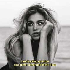 black and white photograph of a woman with her hands on her face by the ocean