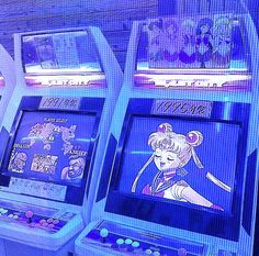 three video game machines sitting next to each other on top of a blue background with images of anime characters