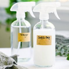 two bottles of liquid sitting on top of a table next to a glove and cloth