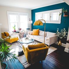 a living room with blue walls and yellow chairs