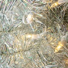 a close up view of a christmas tree's lights and tinsel garlands