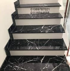 the stairs are made of marble and have black treads with white lettering on them