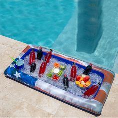 an inflatable hot tub filled with drinks and fruit next to a swimming pool