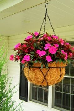 a hanging planter filled with pink flowers