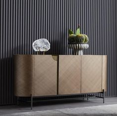 a sideboard with two vases sitting on top of it next to a wall