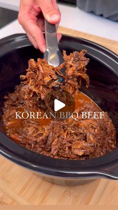 a person is spooning some food out of a slow cooker with the words korean bbq beef on it