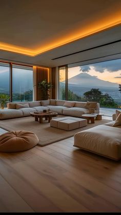 a living room filled with lots of furniture next to large windows and floor to ceiling windows