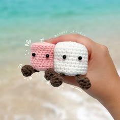 two small crocheted objects are held in the palm of someone's hand