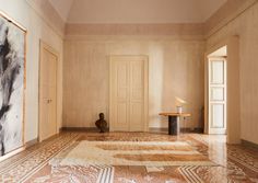 an empty room with marble floors and paintings on the walls