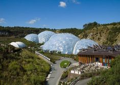 an aerial view of several large domes in the middle of a green field with trees on both sides