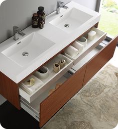 a bathroom vanity with two sinks and mirrors on the wall next to a large window