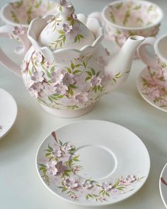 the tea set is decorated with pink flowers