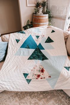 a bed with a white and blue quilt on it