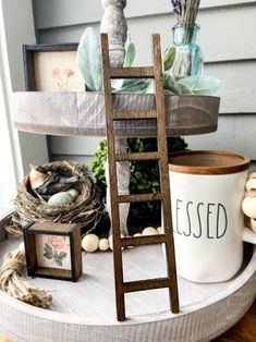 a wooden ladder sitting on top of a table next to a white cup and potted plant