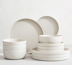 a stack of white plates and bowls sitting next to each other