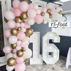 the balloon arch is decorated with pink, white and gold balloons for an anniversary celebration