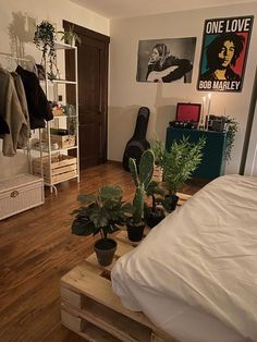 a bed room with a neatly made bed and plants