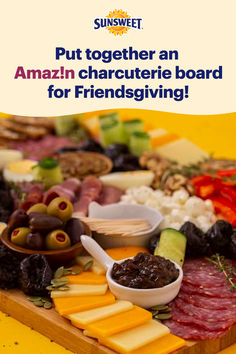 a wooden cutting board topped with lots of different types of cheeses and meats