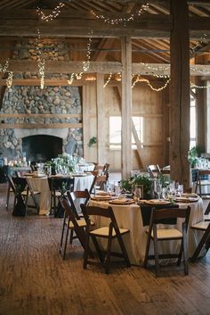 the tables and chairs are set up in the barn for an elegant dinner or reception