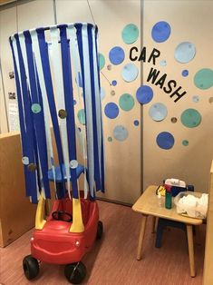 a child's toy car wash station with blue and white streamers hanging from the ceiling