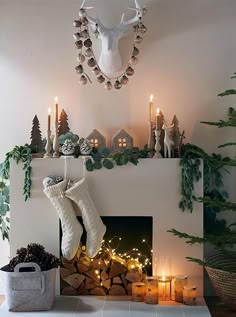 a living room decorated for christmas with candles, stockings and deer head on the mantle