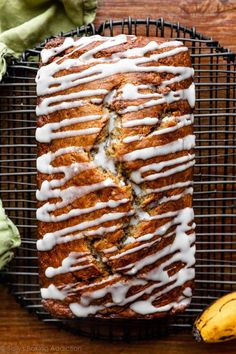 a loaf of banana bread with icing on a cooling rack