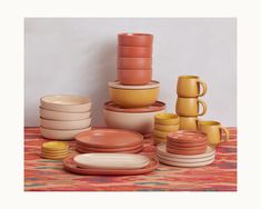 a table topped with lots of different colored dishes and cups on top of each other