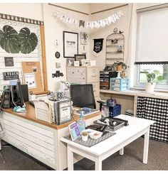 an office with desks, shelves and pictures hanging on the wall above it's windows