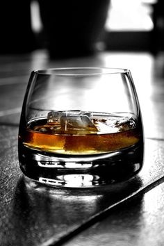 a glass filled with liquid sitting on top of a table