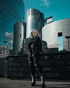 a woman standing in front of some tall buildings