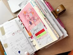 an open planner book sitting on top of a wooden desk