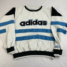 Adidas Vintage Retro Spell Out Ribbon Strips Blue White Adidas Front Logo Sweater with Blue Ribbon Stripes, Black Panels in Arms and Black and White Banded Hem This sweatshirt is in very good condition, with no holes, rips, or tears. Please zoom in on the photos to see the quality of this vintage Adidas sweatshirt. Please look at the photos for they are the best description of this item.   Feel free to contact me with any questions.   Thank you for looking at my post. Measure Where To Find Vintage Nike Sweaters, Vintage Adidas Sweater, Vintage Streetwear Top With Logo Print, Vintage White Sweatshirt With Graphic Print, Vintage Sports Sweatshirt With Logo Print, Vintage White Sweatshirt With Logo Print, Vintage Long Sleeve Top With Logo Print, Vintage Sports Tops With Logo Print, Vintage White Sweatshirt For College