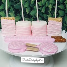 there is a cake with pink frosting on it and some marshmallows