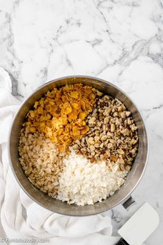 rice, lentils and other ingredients in a bowl on a marble counter top with a spatula