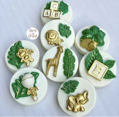 there are many buttons with animals and letters on them, all decorated in gold and green