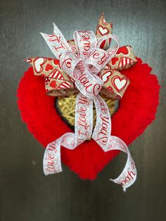 a heart shaped wreath with candy wrapped in ribbon