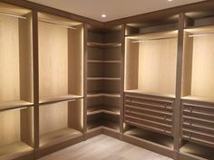 an empty walk in closet with wooden shelves