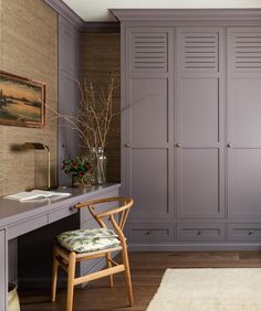 a chair and desk in a room with gray cabinets