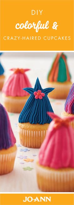 cupcakes with colorful frosting on them sitting on a table