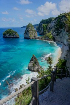 stairs leading down to the beach with blue water