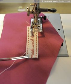 a sewing machine with a piece of fabric next to it on a pink table cloth