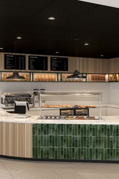 the interior of a fast food restaurant with green tiles on the wall and counter tops