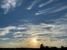 the sun is setting behind some clouds in the sky