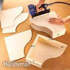 a person using a power drill to cut out wood shapes on a table with measurements