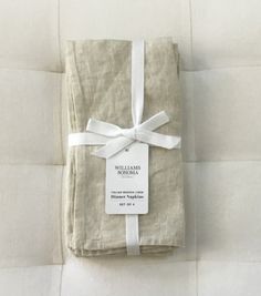 two folded linens tied together with a white ribbon and tag on the top one