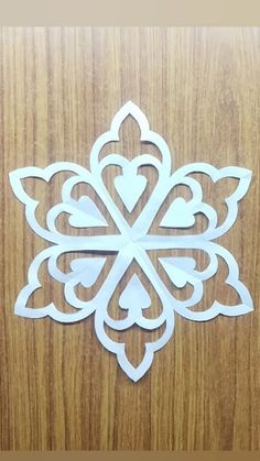 a cut out snowflake sitting on top of a wooden table