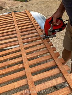 a man using a power drill to attach the slats on top of a bed frame