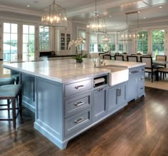 a large kitchen with an island in the middle and chairs around it's perimeter