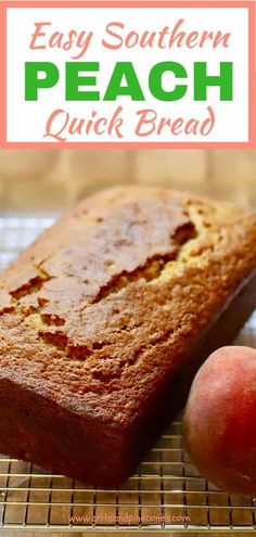 a loaf of bread sitting on top of a cooling rack next to two peaches