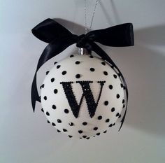 a christmas ornament with the letter w hanging from it's side, decorated with black and white polka dots